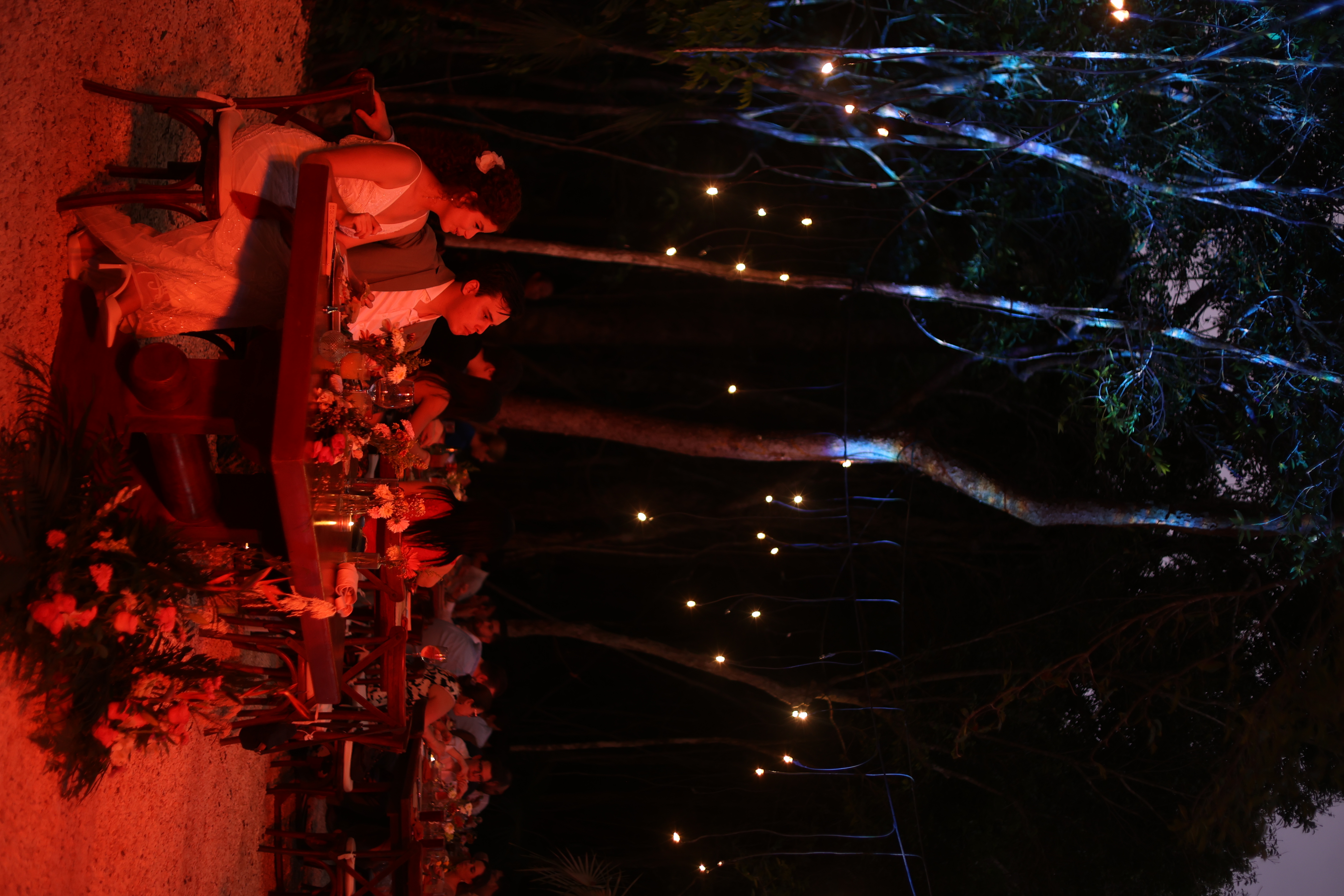 String lights glowing over the jungle wedding dinner at night