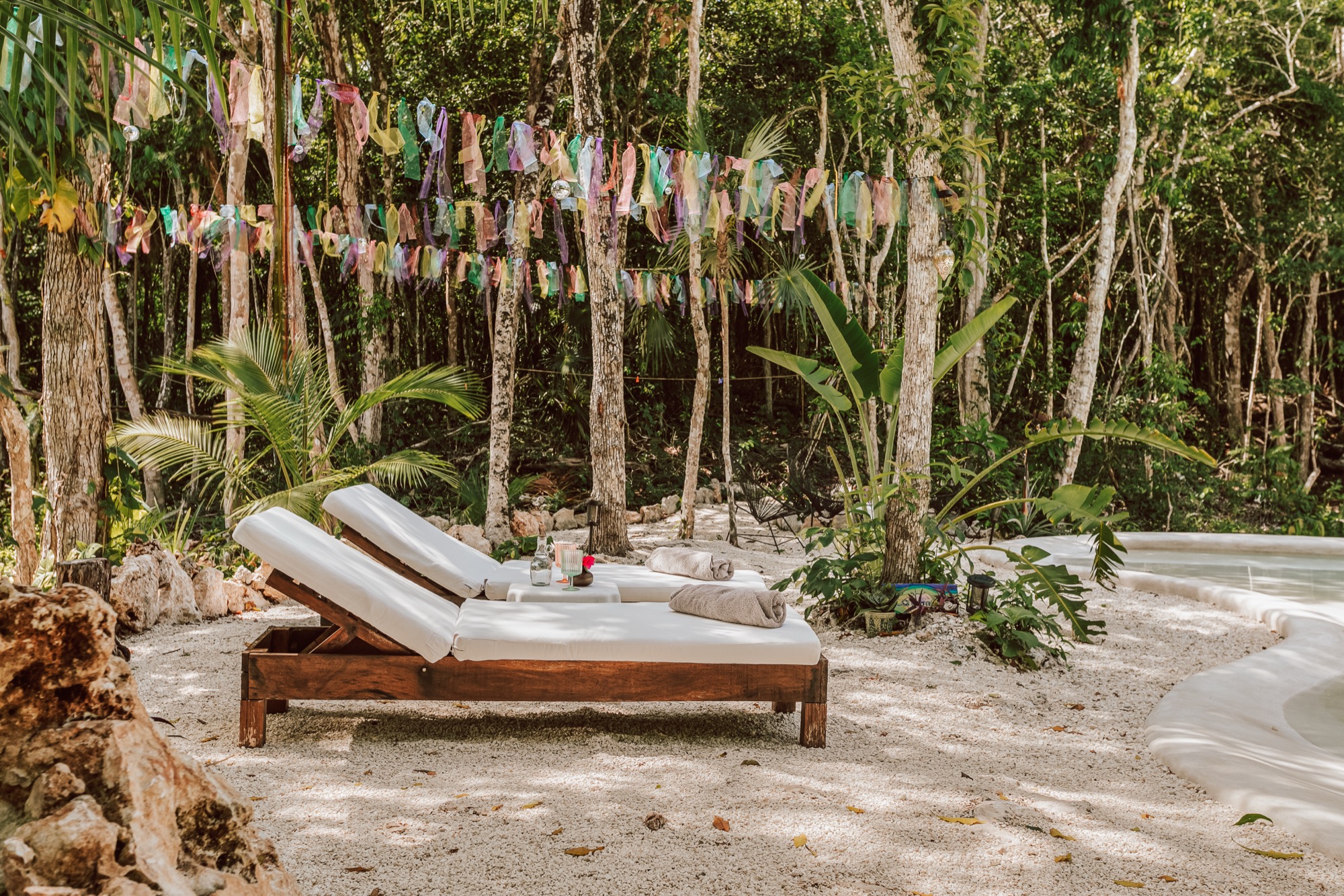 Sunbeds beside the cenote pool surrounded by jungle